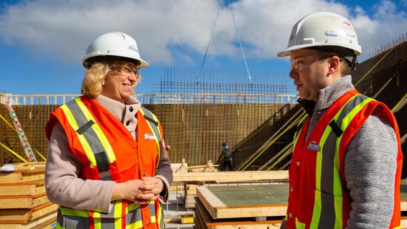 Laurel Broten, President and CEO of NSBI, speaks with a worker at a construction site in Nova Scotia.